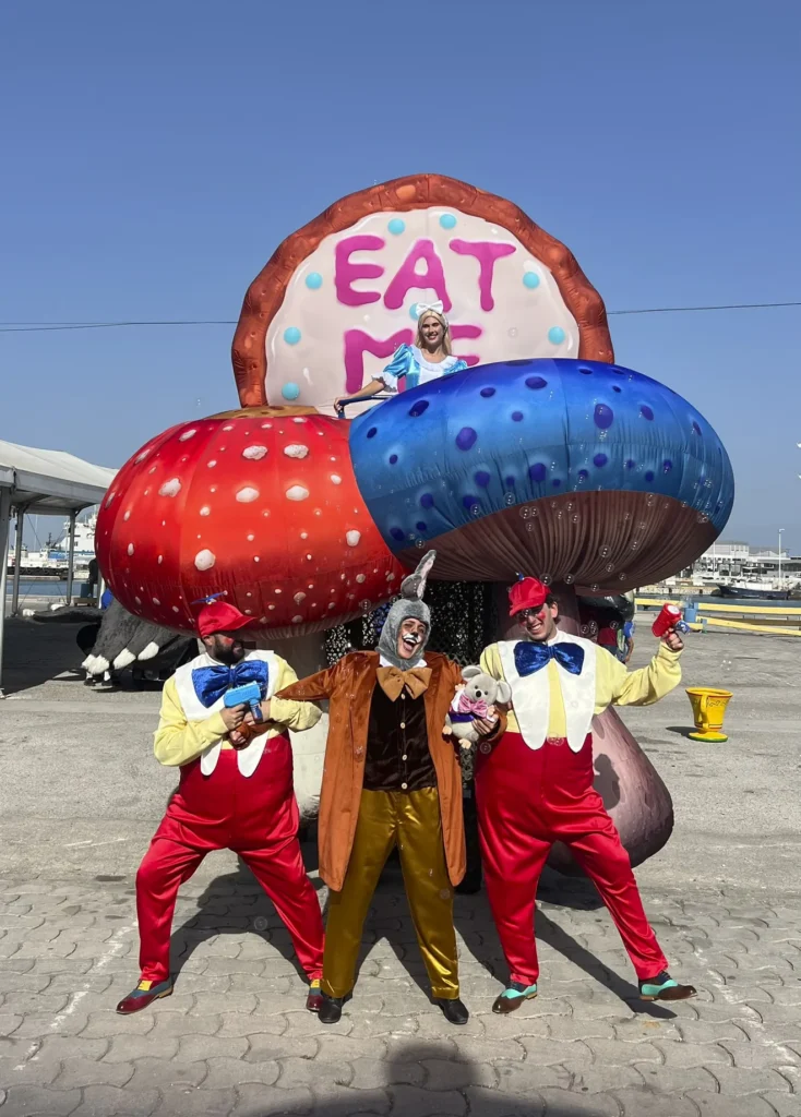 Alicia sobre los hongos gigantes junto a figurantes del espectáculo Wonderland