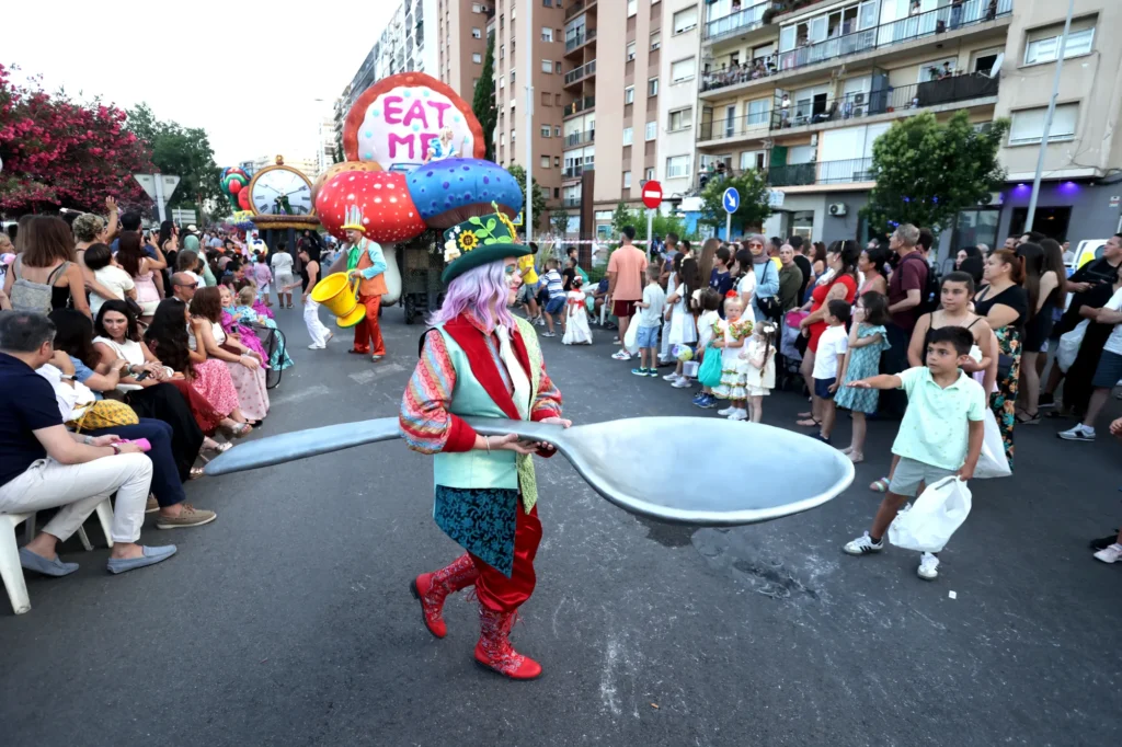 Figurante con cuchara gigante junto a la carroza Eat Me en el espectáculo Wonderland